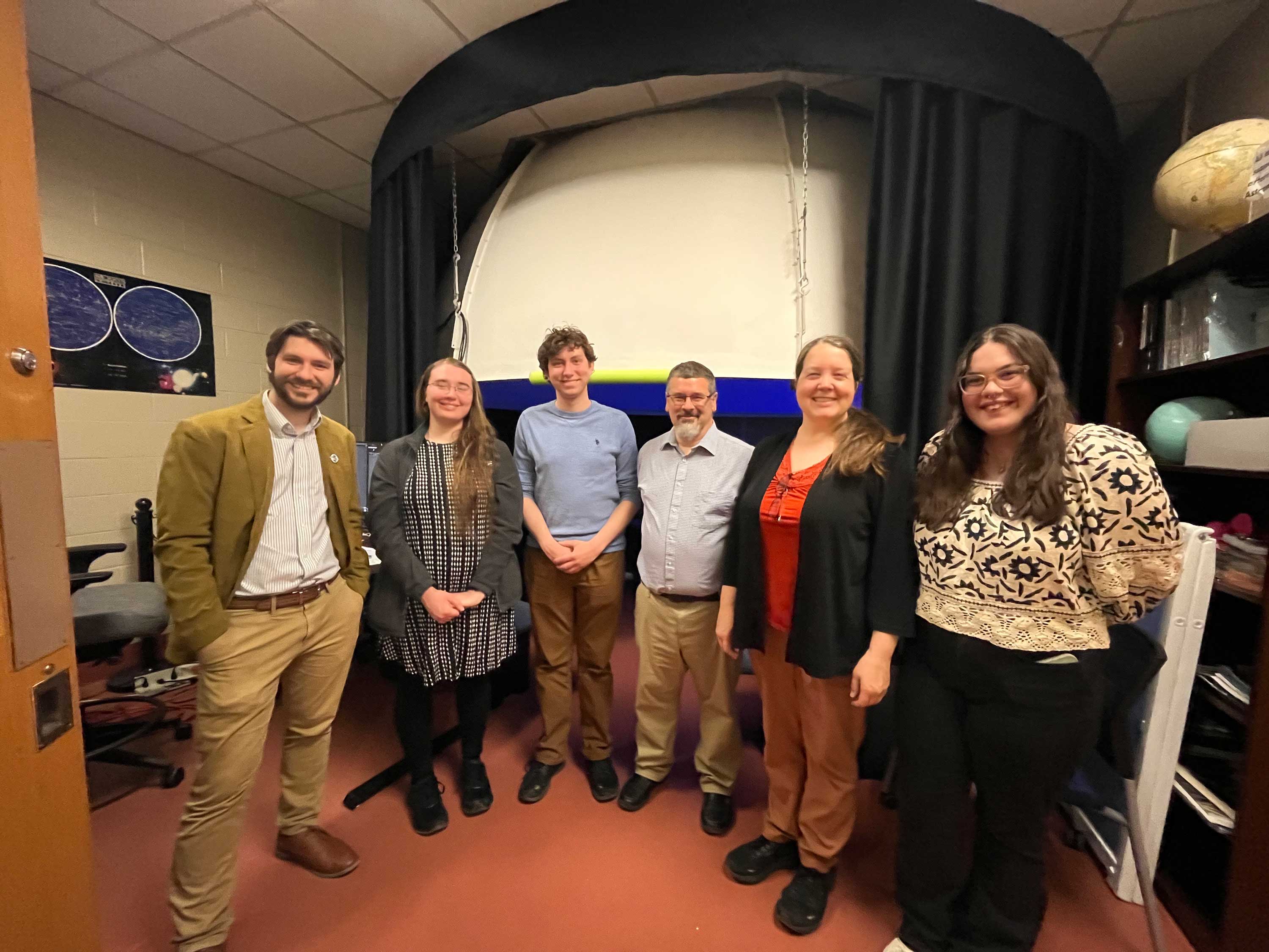 group of researchers in planetarium