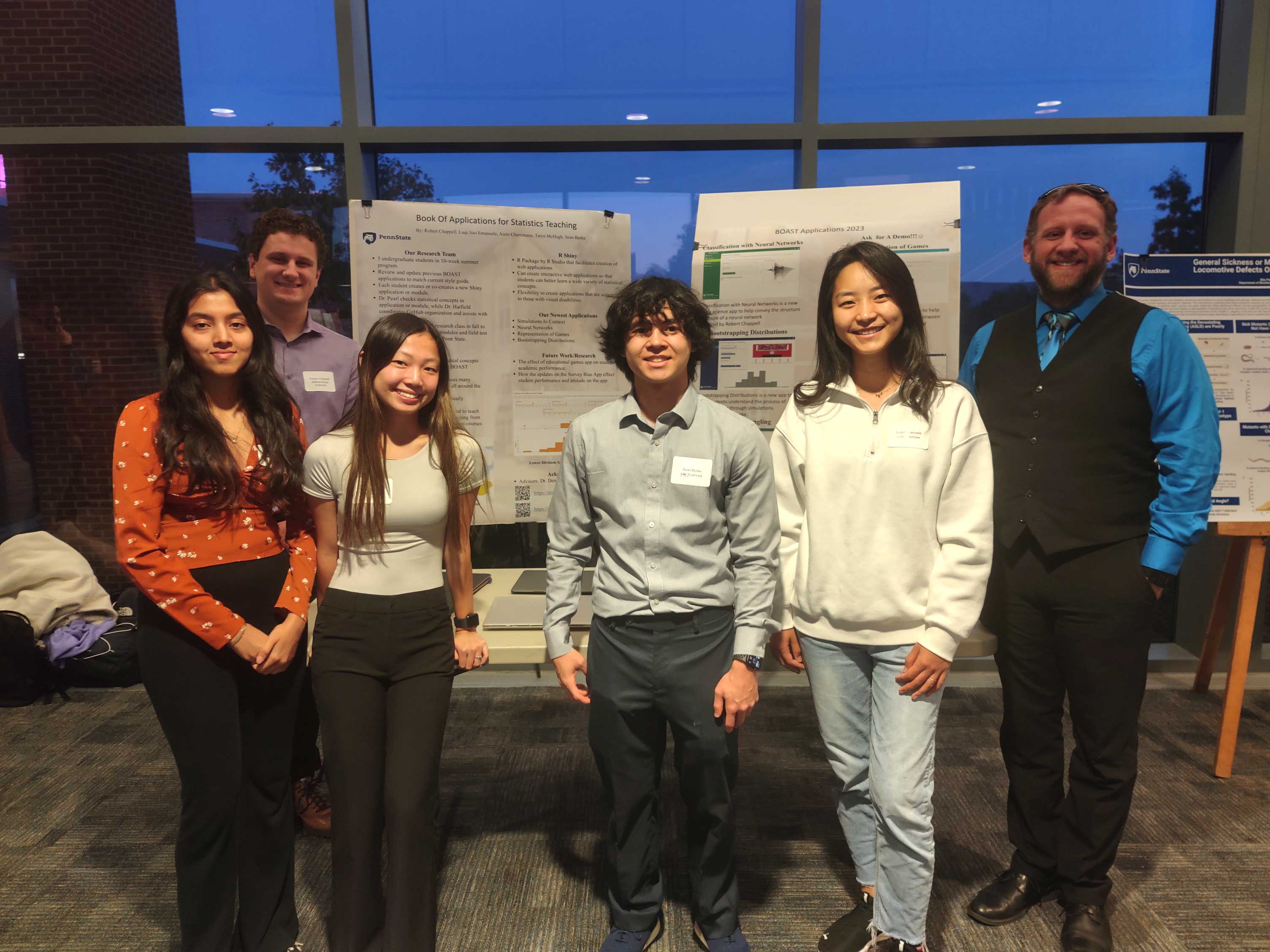 students and faculty stand in front of poster