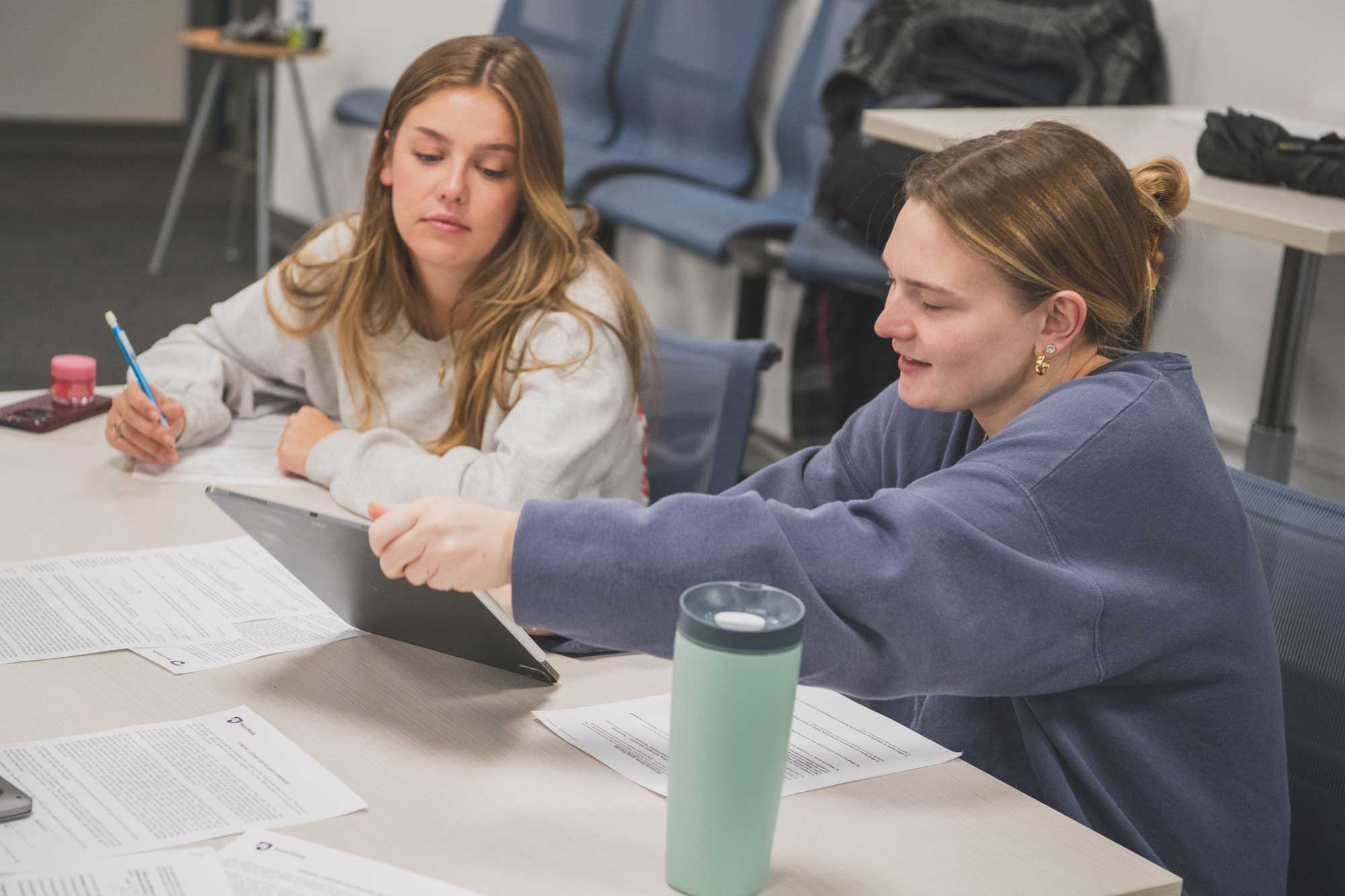 two students look at an ipad 