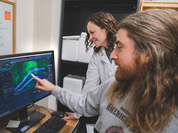 Chad Brunswick points to computer screen while Janine Kwapis watches