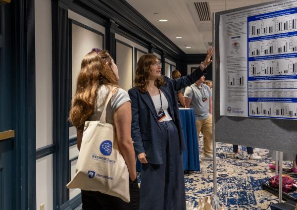 A member of the Big Ten Neuroscience conference giving a poster presentation.
