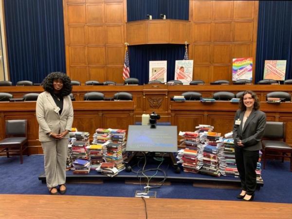Ellis and friend stand in front of pile of books within US capitol