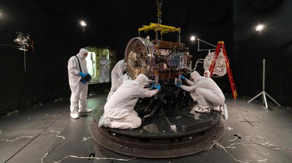 engineers in clean room suits work on LINK satellite that will boost SWIFT