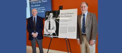 Harry Allcock (left) and Thomas Mallouk pose with a new poster about Allcock’s pioneering research that will be permanently exhibited in the Millennium Science Complex. Credit: Maria Landschoot.
