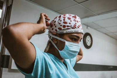 Woman ties on surgical mask