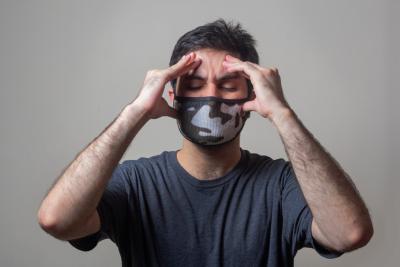 man in mask with hands on head