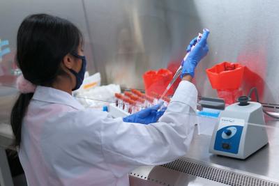 Woman uses pipette in fume hood