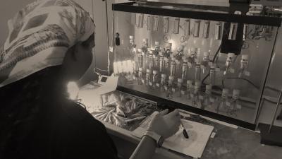 Woman looks at a rack of vials