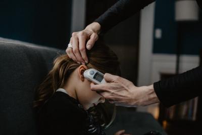 Girl having her temperature checked in ear. Credit: Unsplash