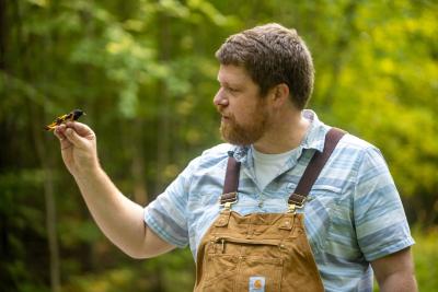 Dave Toews holds a warbler
