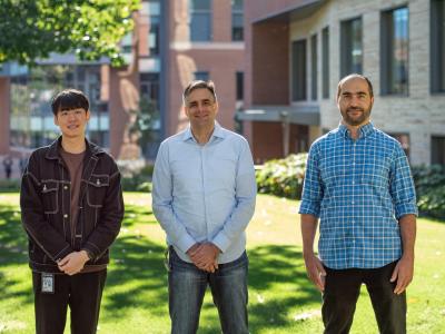 Three researchers stand outside