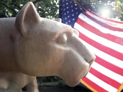 Nittany lion statue with U.S. flag