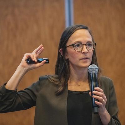 Tamma Carleton holding microphone and gesturing
