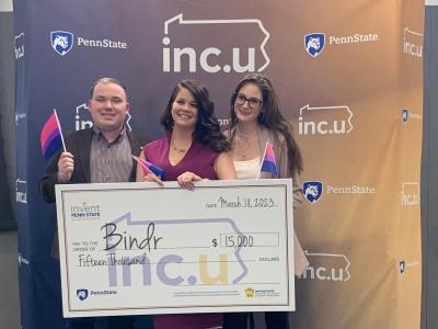 Student members of the start Bindr hold a large check in front of inc.u banner