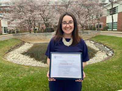 Victoria Bonnell outside holding plaque