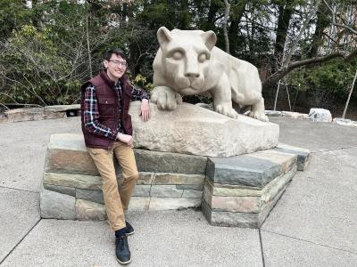 Levendosky sits in front of nittany lion statue