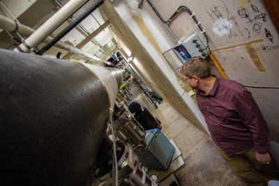 ABE FALCONE, RESEARCH PROFESSOR OF ASTRONOMY and astrophysics, looks down the length of the 47-meter, long-cell X-ray beam in the subbasement of Osmond Laboratory. Credit: Nate Follmer - Penn State.