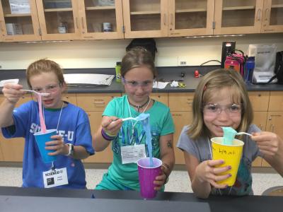 Haunted U students pull slime out of cups with spoons