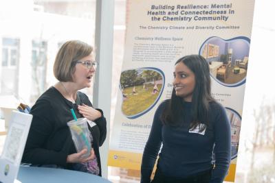 A member of the faculty talks with a graduate student during the Science Equity and Diversity Conference poster session.