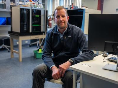 Andrew Patterson leans on desk