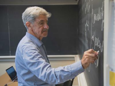 Leonid Berlyand writes on chalkboard