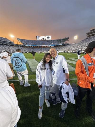 Abby Han with her dad on the sideline of a Penn State football game.