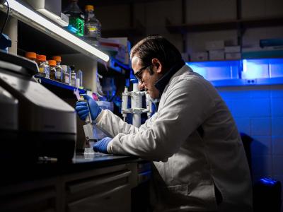 Sabab Hasan Khan, assistant research professor of biochemistry and molecular biology, sitting at a lab bench.