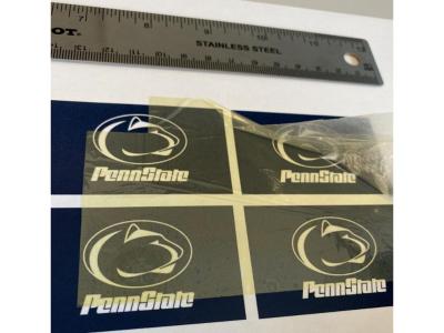 The new polymer capacitor makes use of the transparent material — pictured, with vintage Penn State athletic marks visible through it — to store four times the energy and withstand significantly more heat.  