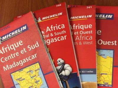 stack of four paper road maps of Africa
