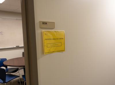 Office doorway with room number 323A and a yellow sign reading “Statistics Consulting Center, Please Knock.”