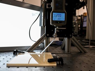 device on tripod lifts tape off of a flat surface