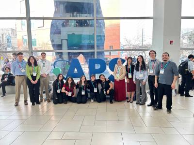 physics REU students gather in front of the APS sign at annual conference