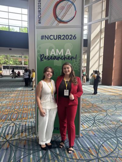Undergrad students at the NCUR 2026 Conference. They are posing in front of a sign that says NCUR2026.