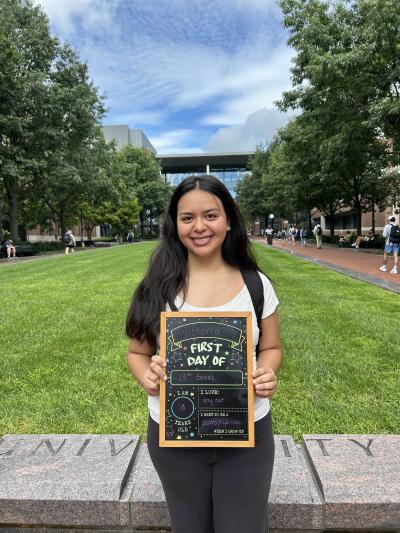 Student holding a first day of school chalkboard on the first day of classes.