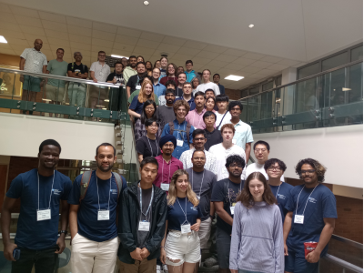 participants wearing name badges gather on staircase for posed photo