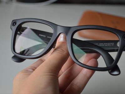 A person holding a pair of glasses.