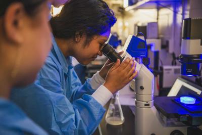 student looks into microscope