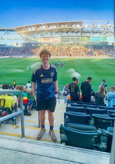 Max Gerhart stands a few steps above a soccer field 