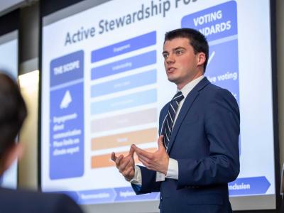 Student Adam Lieb wears suit and presents for business ethics team