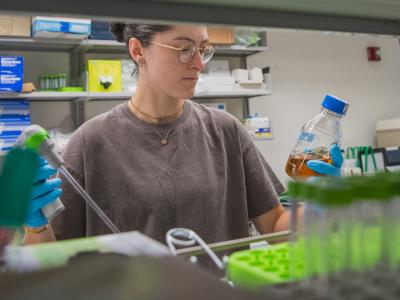 Graduate student Julia Mudryk holds a vial in the lab