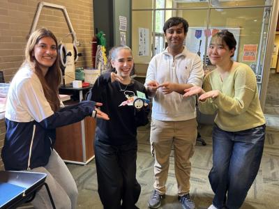SURE students hold a model car that they built