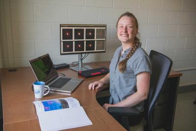 Charlotte Ward poses at her desk 