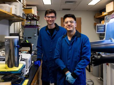 Jonathan Kuo and Alexander Arnette wearing lab coats in the lab smiling at camera