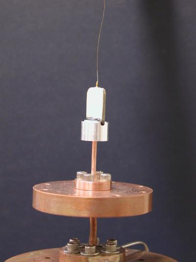 A photo of the torsional oscillator we used in our experiment:  The torsional oscillator is secured onto a cooling stage of our dilution refrigerator. The torsion rod, the torsion bob and the central electrode are shown. The fixed drive and detection electrodes are not shown. Photo credit: Penn State