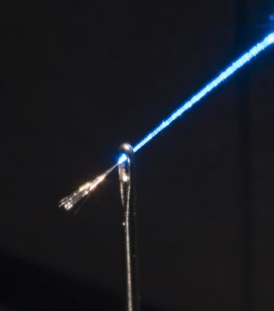 Credit: Neil Baril, Penn State This photo shows a glass fiber with a bundle of semiconductor wires emanating from it. Each wire is just 2 microns in diameter — 20 times smaller than a human hair. The glass fiber is glowing from blue laser light.
