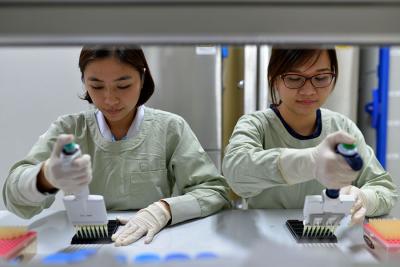 Graduate students Nguyen Ha Thao Vy (left) and Tran Thi Nhu Thao of the Oxford University Clinical Research Unit in Ho Chi Minh City, Vietnam, perform protein microarray analysis to identify influenza antibodies in human blood. New research reveals that these antibodies may provide insight into the timing of previous H1N1 influenza infections. Credit: Oxford University Clinical Research Unit