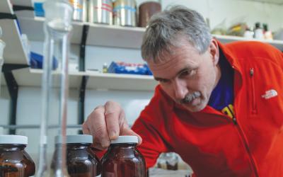 Frank Dorman reviewing containers of samples in his research lab.