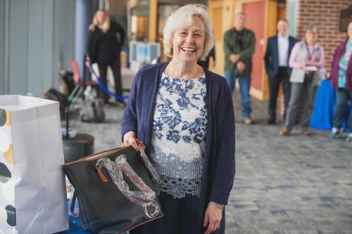 Jackie Bortiatynski smiling while holding a Penn State purse.