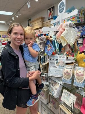 Julianne Gardner with her son in front of a bottimals display in store.