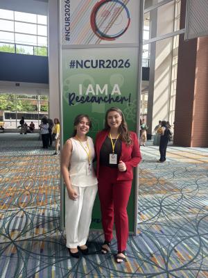 Undergrad students at the NCUR 2026 Conference. They are posing in front of a sign that says NCUR2026.